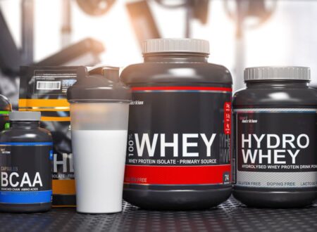 Lactose free bodybuilding supplements including whey protein isolate, hydro whey, and BCAA capsules displayed with protein shaker in gym setting